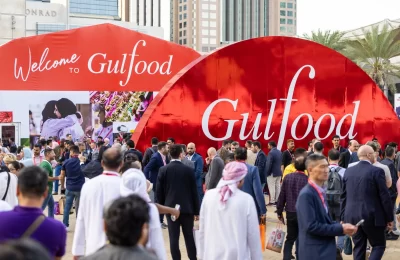 gulfood Expo outside, showing many people and a big red outdoor banner that says gulfood.